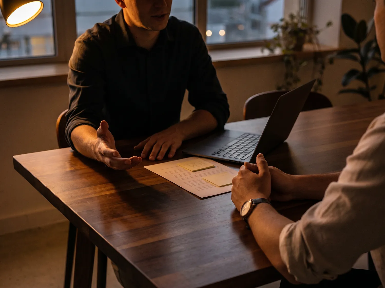 Twee collega's in gesprek aan een werktafel